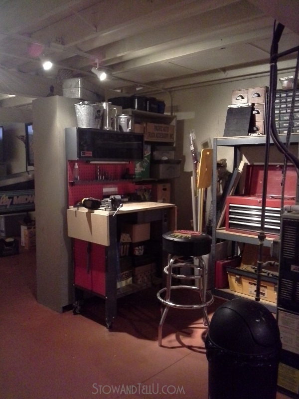 Basement with an open space plan has a hidden workshop area tucked behind two tall cabinets at Stow and Tell U