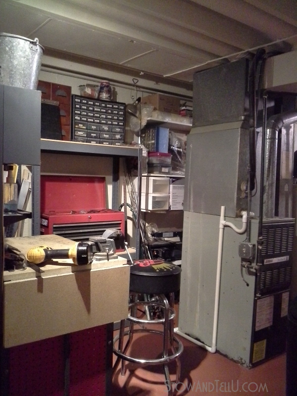 Basement with an open space plan has a hidden workshop area tucked behind two tall cabinets at Stow and Tell U