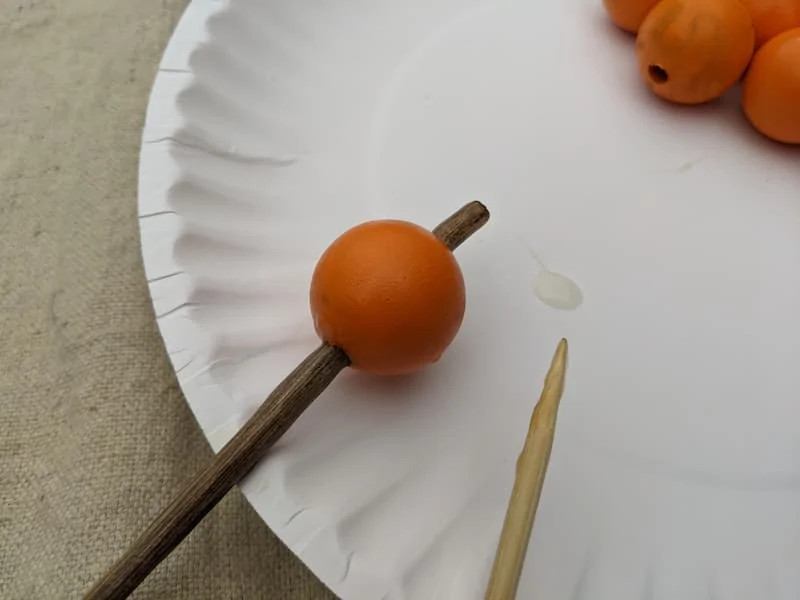 Orange painted wood bead on skewer